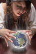 Mixed race fortune teller with crystal ball shaped like globe