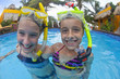 Caucasian girls snorkeling in swimming pool