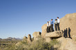 Business people standing on rock in desert