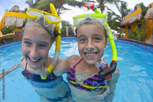 Photo: Caucasian girls snorkeling in swimming pool Caucasian girls snorkeling in swimming pool
