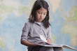 Korean girl reading book near map