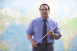 Hispanic businessman standing near map with pointer