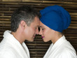 Caucasian couple in robes smiling at each other