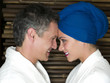 Caucasian couple in robes smiling at each other