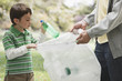 Caucasian father and son picking up litter together