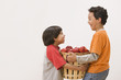Hispanic brothers carrying basket of apples