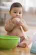 Mixed race baby boy playing with wooden spoon and bowls