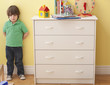 Sad Caucasian boy standing in bedroom