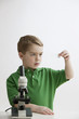 Caucasian boy with microscope looking at specimen slide