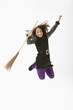 Mixed race girl in Halloween costume jumping and cheering