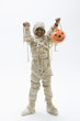 Black boy in mummy costume holding jack o'lantern