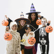 Children in Halloween costumes holding jack o'lanterns