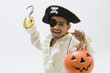 Hispanic boy in pirate costume holding jack o'lantern