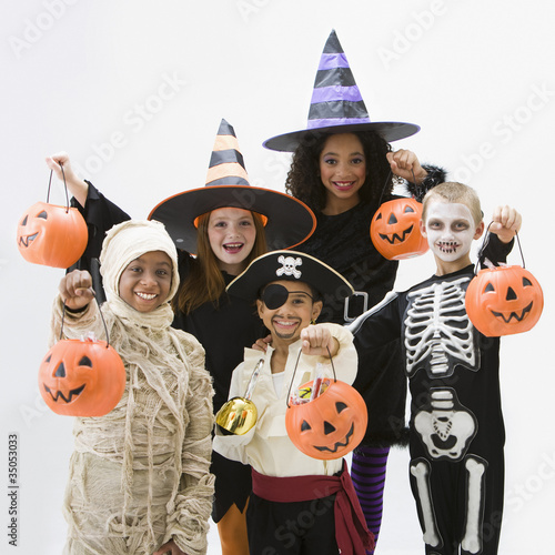 Photo: Children in Halloween costumes holding jack o'lanterns Children in Halloween costumes holding jack o'lanterns