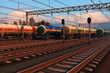 Freight trains with fuel tank cars in sunset Freight trains with fuel tank cars in sunset