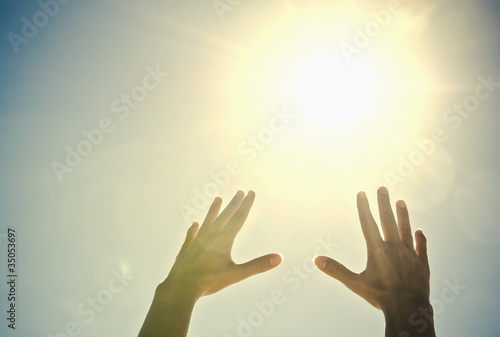 Photo: Mixed race woman's hands reaching toward sun Mixed race woman's hands reaching toward sun