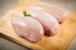 Raw chicken breasts on cutting board