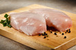 Raw chicken breasts on cutting board