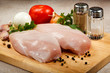 Raw chicken breasts on cutting board