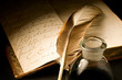 Old book with feather and inkpot