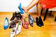 Frau mit vielen Schuhen zur Auswahl