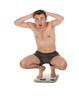 frightened squats on scale young man in panties