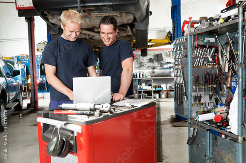 Photo: Mechanics with laptop in garage Mechanics with laptop in garage