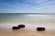 Discarded old tyres on beach Discarded old tyres on beach