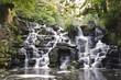 Beautiful waterfall cascades over rocks in lush forest landscape