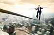 Business man balancing on the rope