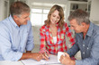Mid age couple with financial advisor at home Mid age couple with financial advisor at home