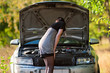 The girl looks at a car engine