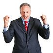 Business man standing with fists clenched in sign of victory