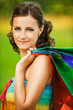 portrait of young smiling woman holding many bags