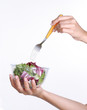 Mano sosteniendo un bowl de ensalada.