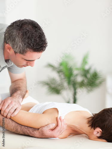 Photo: Woman getting a shoulder-stretching Woman getting a shoulder-stretching