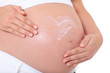 Schwangere Frau cremt ihren Babybauch ein
