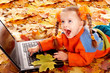Girl child in autumn orange leaves with laptop. Girl child in autumn orange leaves with laptop.