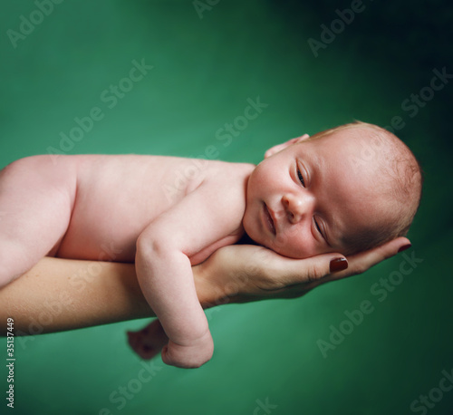 Photo: New born baby resting on mom's hand. New born baby resting on mom's hand.