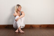 Beautiful young blonde woman sitting on floor