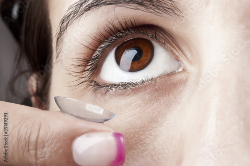 Photo: Woman puts on a Contact Lens Woman puts on a Contact Lens