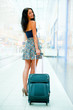 Portrait of young woman walking inside modern international airp