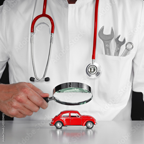Foto: Checking a red car carfully with magnifier Checking a red car carfully with magnifier