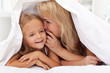 Woman and little girl sharing a secret