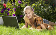 Foto: A smiling young girl with laptop outdoors A smiling young girl with laptop outdoors