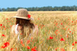 young girl sitting on the wheat field .