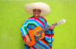 Photo : Mexican typical man playing guitar poncho Mexican typical man playing guitar poncho
