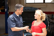 Young woman collecting car from repair shop