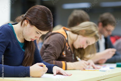 Photo: pretty female college student sitting in a classroom pretty female college student sitting in a classroom