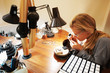 Attractive goldsmith looking at her work